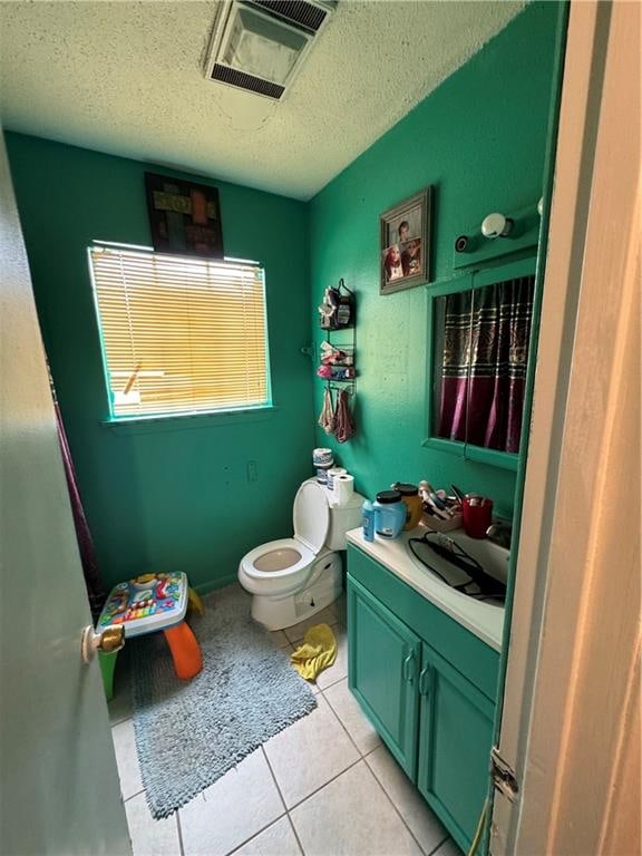 bathroom featuring vanity, a textured ceiling, toilet, and tile patterned floors