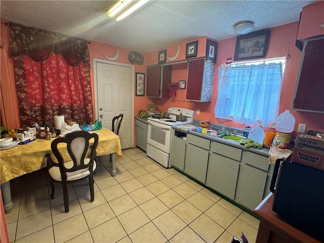 kitchen featuring a textured ceiling, light tile patterned floors, and white range