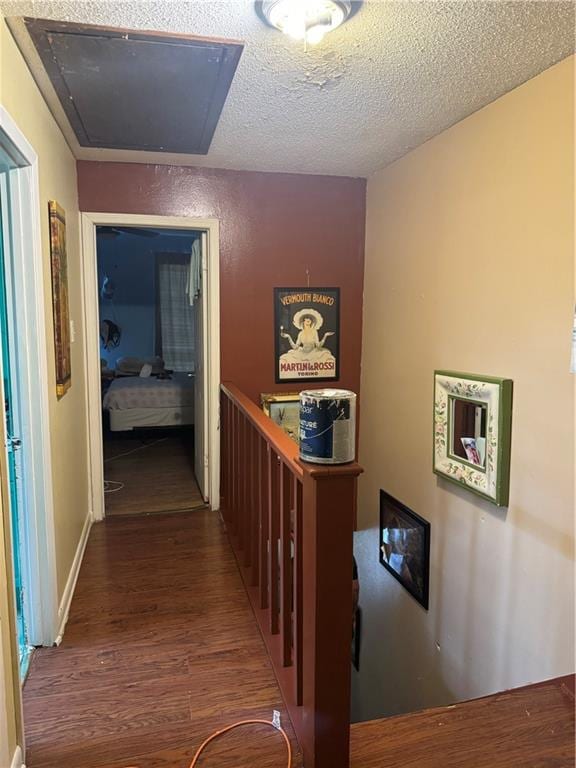 corridor with a textured ceiling and hardwood / wood-style floors