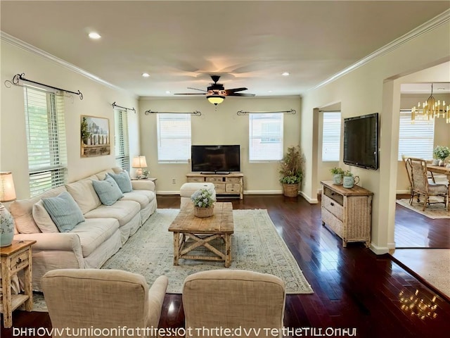 living area featuring baseboards, ornamental molding, dark wood-style flooring, and ceiling fan with notable chandelier