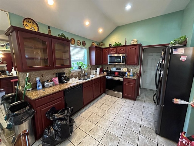 kitchen with light tile patterned flooring, black appliances, lofted ceiling, and decorative backsplash