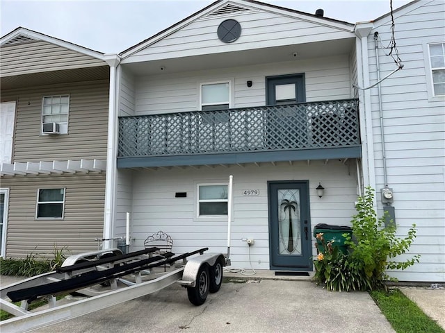 rear view of property with cooling unit and a balcony