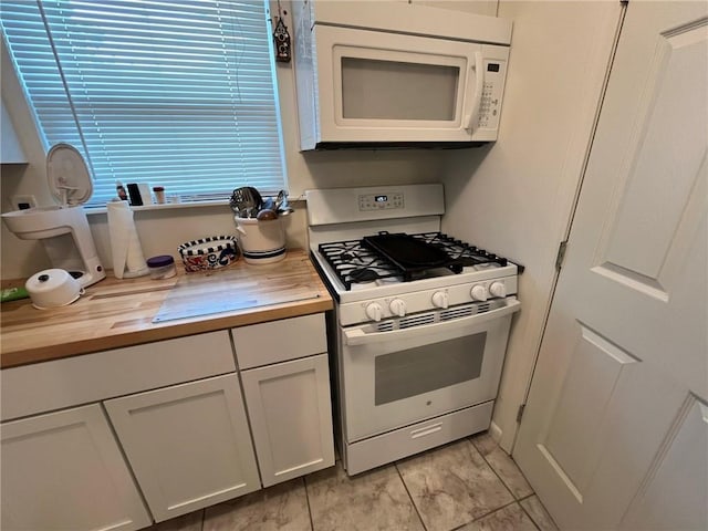 kitchen with white cabinetry, wood counters, and white appliances