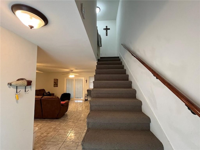 stairway featuring tile patterned flooring and ceiling fan