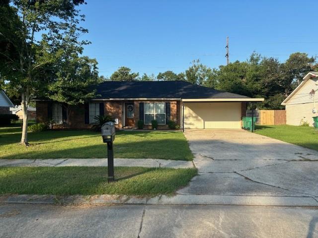 single story home with a garage and a front lawn