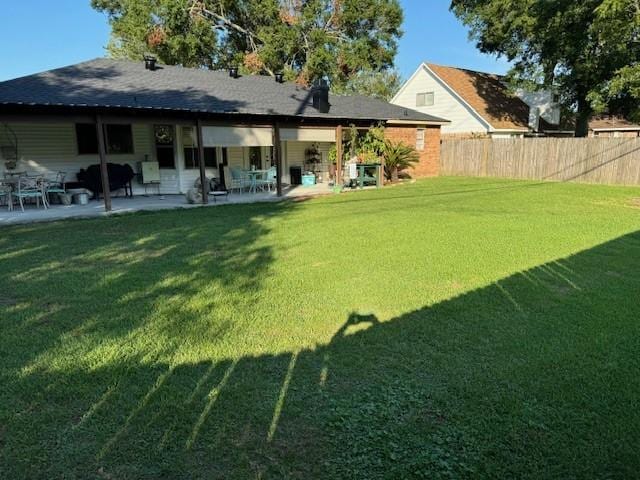 back of property with a patio area and a lawn