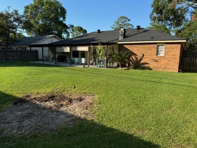 rear view of property with a patio area and a lawn