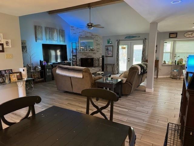 living room with vaulted ceiling with beams, ceiling fan, french doors, and light hardwood / wood-style flooring