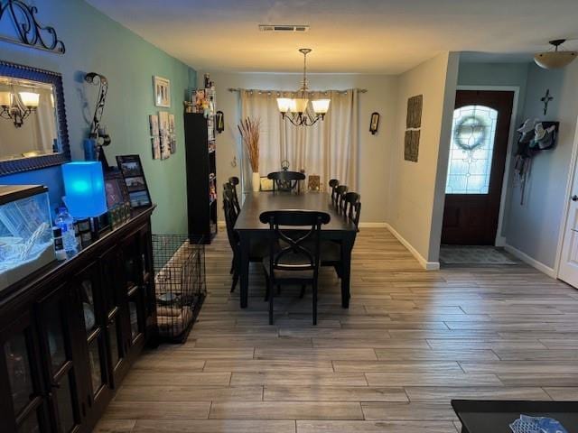 dining space with a chandelier and hardwood / wood-style floors