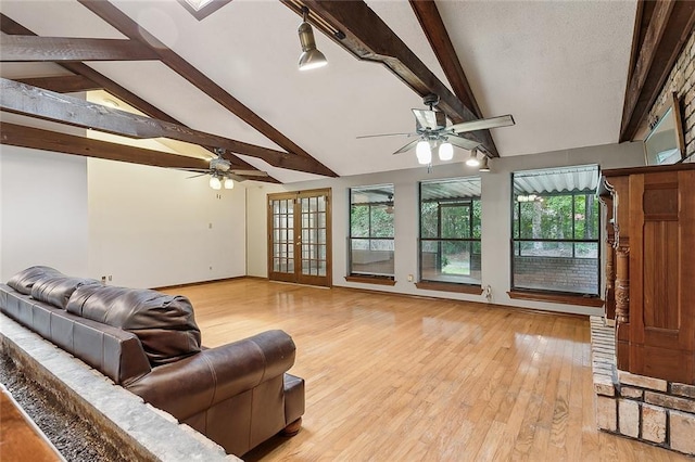 living room featuring light hardwood / wood-style floors, lofted ceiling with beams, plenty of natural light, and ceiling fan