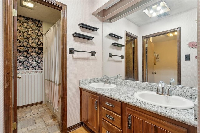 bathroom with dual vanity and tile patterned flooring