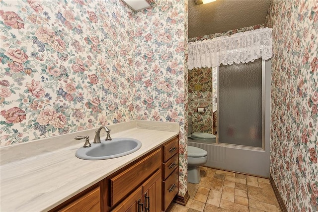 full bathroom featuring combined bath / shower with glass door, tile patterned floors, toilet, and vanity