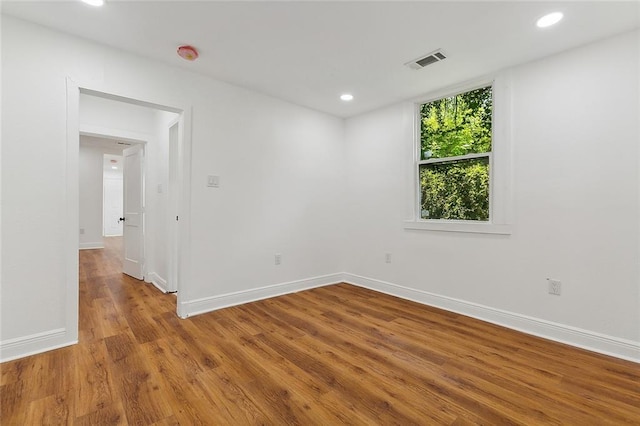 spare room with baseboards, visible vents, wood finished floors, and recessed lighting