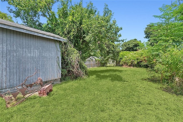 view of yard featuring an outbuilding and fence