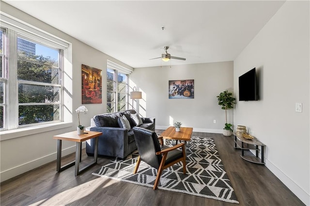 living room featuring ceiling fan, dark wood-type flooring, and a wealth of natural light