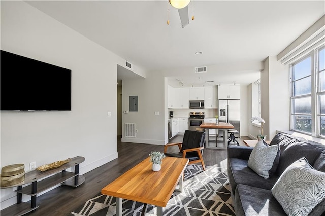 living room featuring ceiling fan, electric panel, and dark hardwood / wood-style flooring