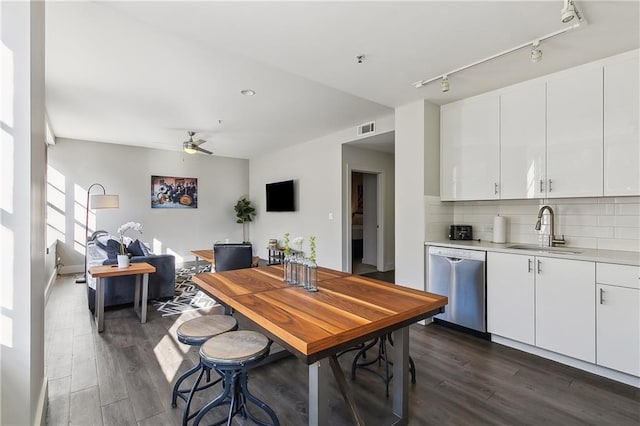 interior space with dark hardwood / wood-style floors, sink, white cabinetry, and stainless steel dishwasher