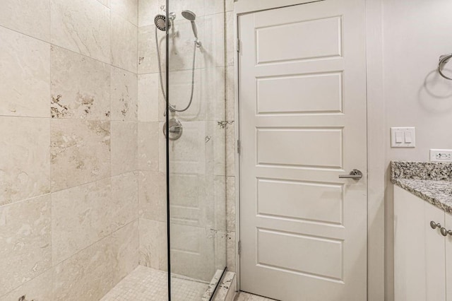 bathroom with a shower with door and vanity