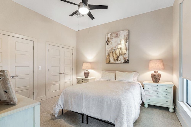 bedroom featuring multiple closets, ceiling fan, and carpet floors