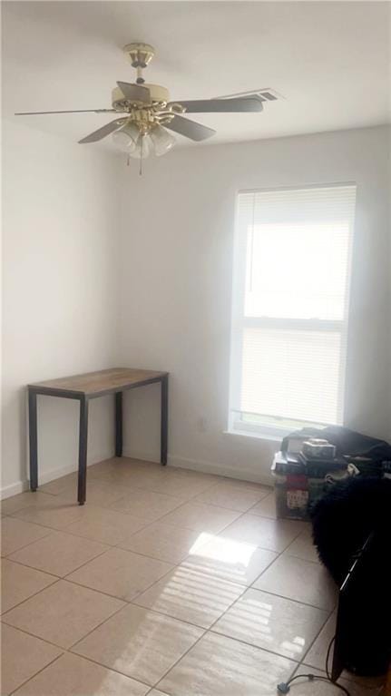 tiled empty room with ceiling fan