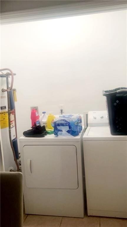 washroom featuring light tile patterned floors, gas water heater, and washing machine and clothes dryer