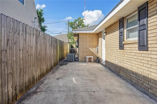 view of side of home featuring cooling unit and a patio