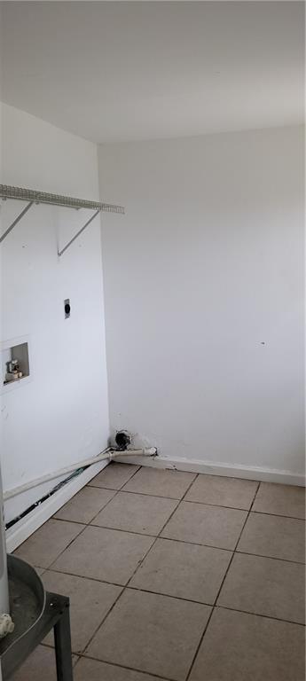 laundry area with hookup for an electric dryer, light tile patterned floors, and hookup for a washing machine