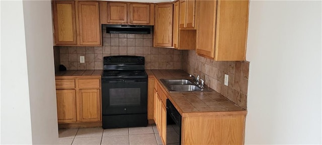 kitchen featuring tile countertops, backsplash, black appliances, sink, and extractor fan