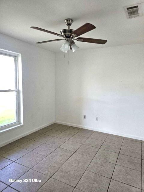 tiled spare room with ceiling fan