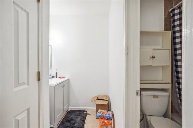 bathroom with tile patterned flooring, vanity, and toilet