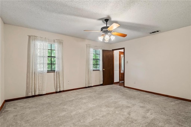 spare room featuring carpet floors, a textured ceiling, and ceiling fan