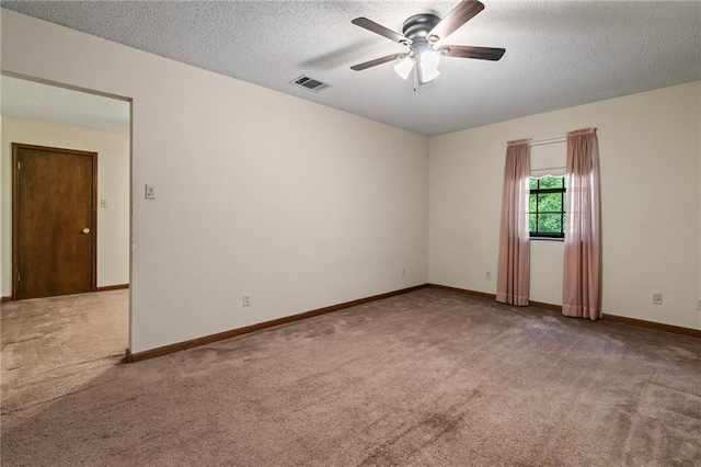 spare room featuring a textured ceiling, ceiling fan, and carpet flooring