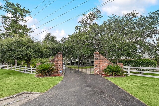 view of gate with a lawn