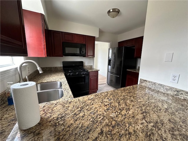 kitchen with black appliances, sink, and light tile patterned floors