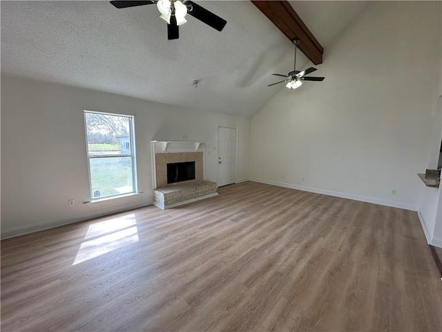 unfurnished living room featuring vaulted ceiling with beams, light hardwood / wood-style flooring, and ceiling fan