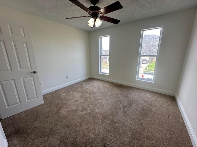 carpeted spare room featuring ceiling fan and a textured ceiling