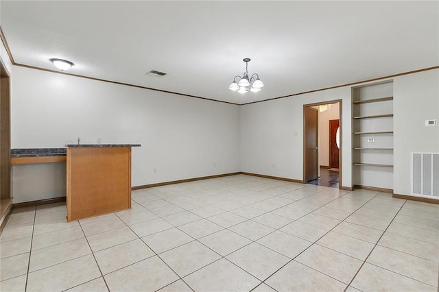 interior space featuring built in features, ornamental molding, a notable chandelier, and light tile patterned floors