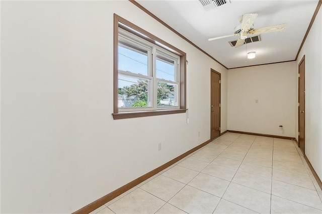 spare room with ceiling fan, ornamental molding, and light tile patterned floors