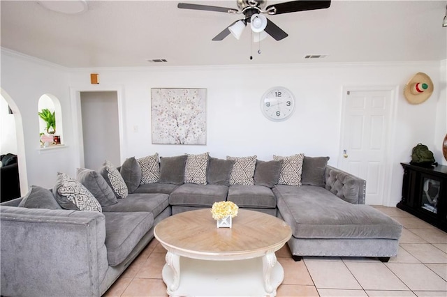 tiled living room with ornamental molding and ceiling fan