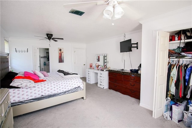 carpeted bedroom with ceiling fan and ornamental molding