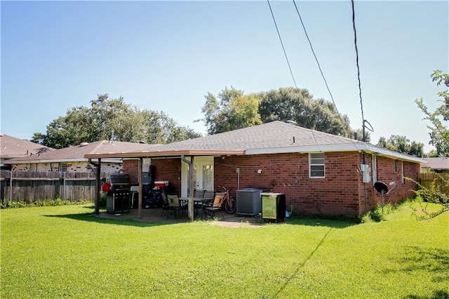 rear view of house featuring a patio, central air condition unit, and a yard