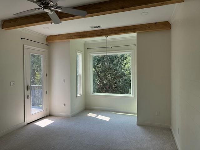 carpeted empty room featuring ceiling fan, crown molding, a wealth of natural light, and beamed ceiling