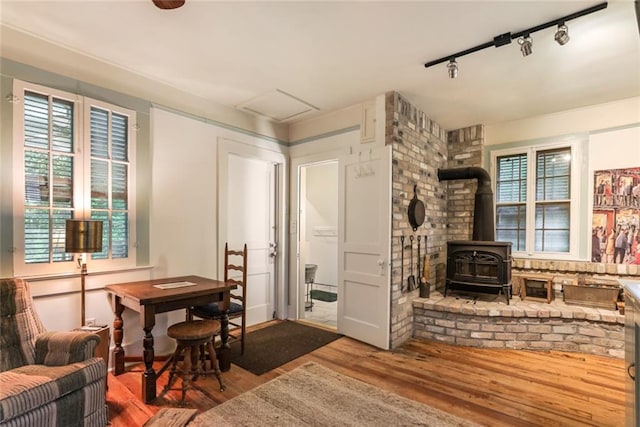 interior space with hardwood / wood-style floors, plenty of natural light, and a wood stove