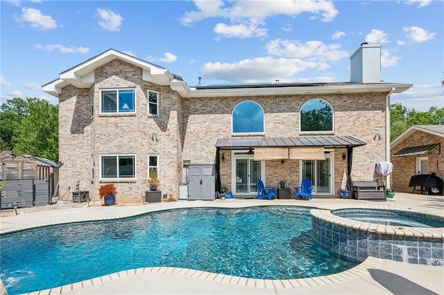 back of house featuring a patio area and a pool with hot tub