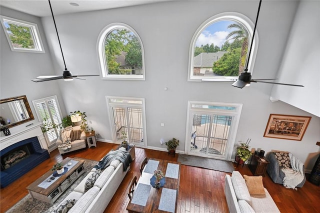 living room with high vaulted ceiling, a healthy amount of sunlight, and dark hardwood / wood-style floors