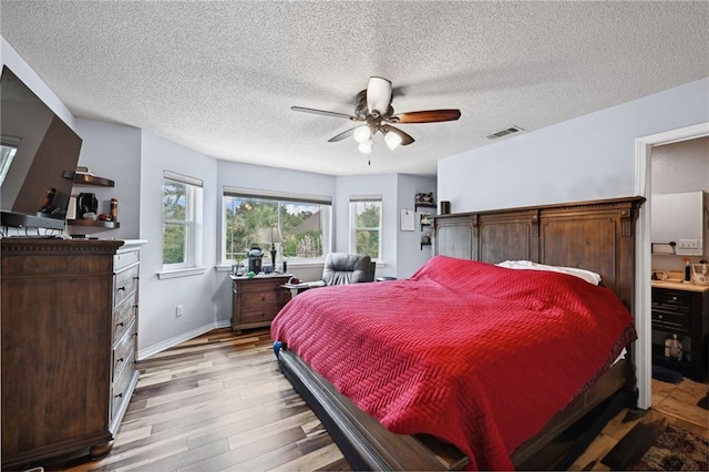 bedroom with dark wood-type flooring, ceiling fan, and a textured ceiling