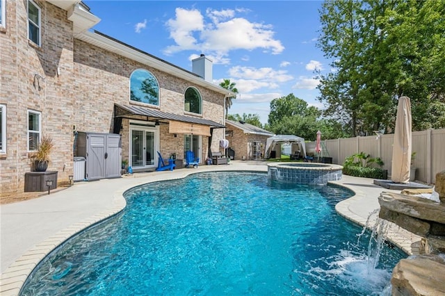 view of swimming pool with an in ground hot tub, pool water feature, and a patio