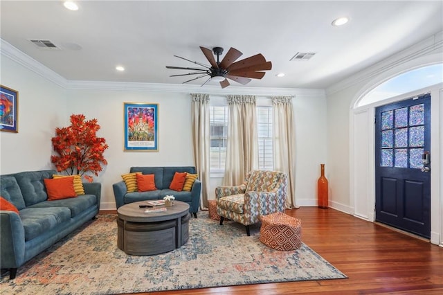 living room featuring wood-type flooring, crown molding, and ceiling fan