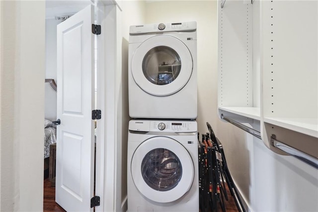 laundry room featuring stacked washer / drying machine and hardwood / wood-style floors