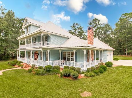 view of front facade with covered porch, driveway, and a front yard